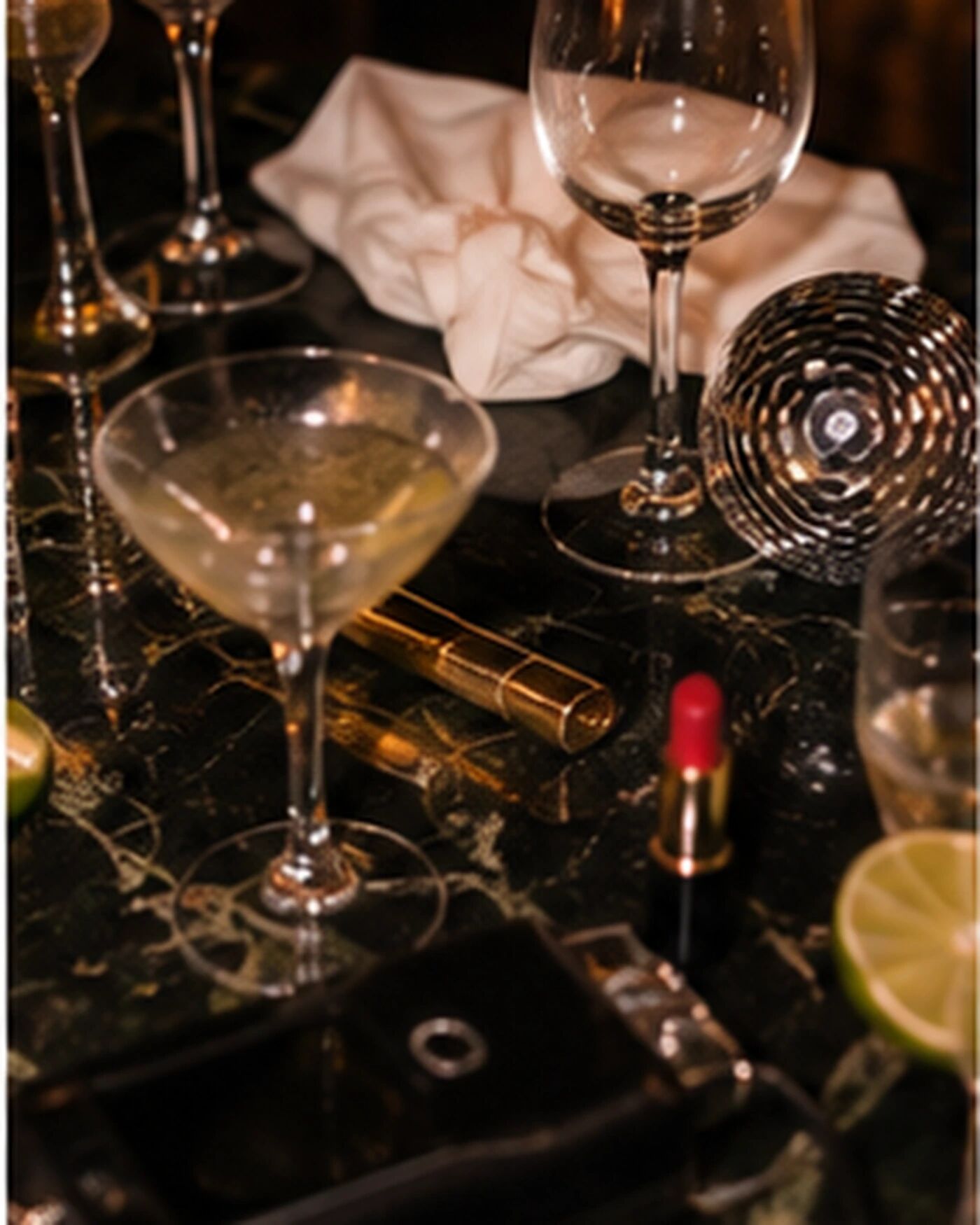 A table of glasses, a disco ball and a lipstick