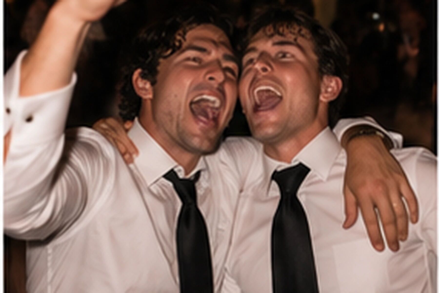 Two men shouting with their arms round each other