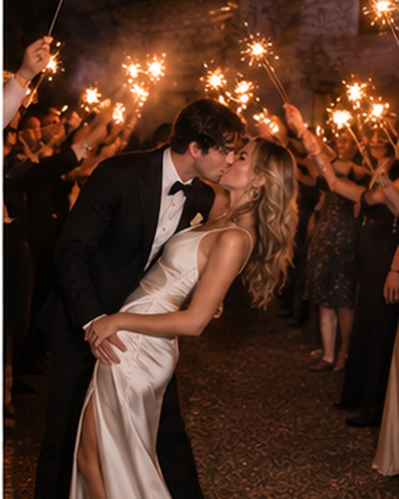 A couple kissing between rows of sparklers
