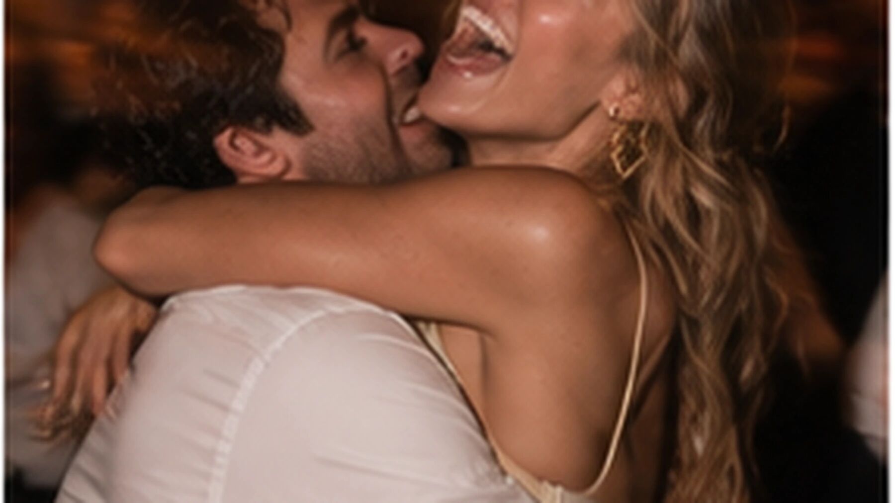 Two guests in a joyful embrace, direct flash