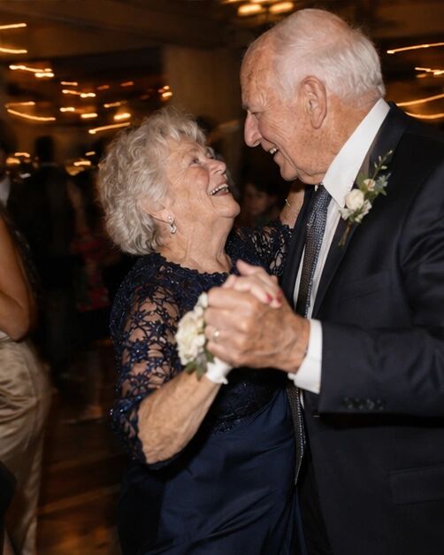Two grandparents slow dancing, laughing