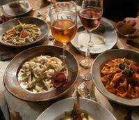 A table of pasta and rosé