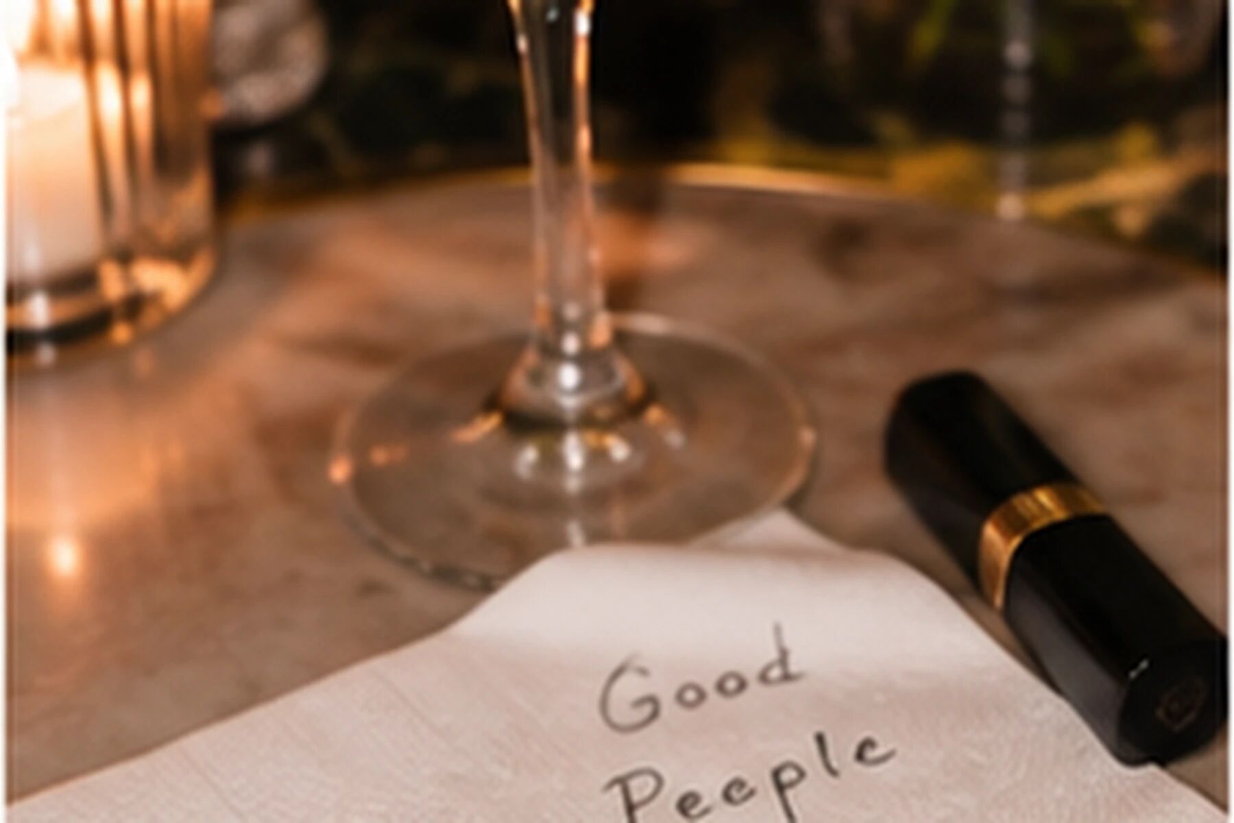 A small card tucked under a glass on the bar